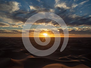 Sand dunes in Morocco, desert landscape, sand texture, tourist camp for night stay, panorama view of sunset over Sahara