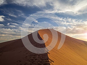 Sand dunes in Morocco, desert landscape, sand texture, tourist camp for night stay, panorama view of sunset over Sahara