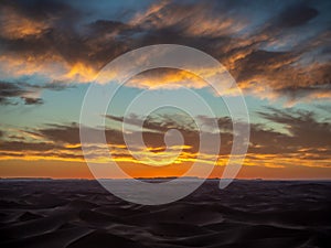 Sand dunes in Morocco, desert landscape, sand texture, tourist camp for night stay, panorama view of sunset over Sahara
