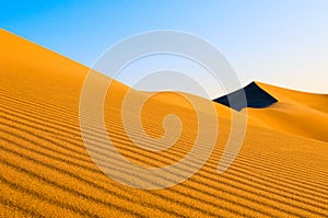 Sand dunes over blue sky