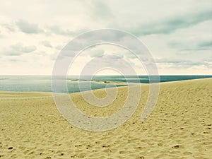 Sand dunes, sea and cloudy sky