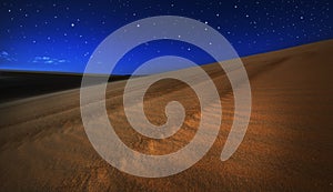 Sand dunes under full moon light and stars