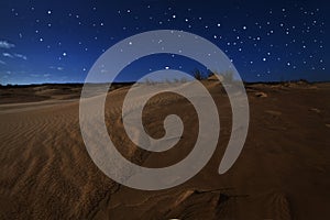 Sand dunes under full moon light and stars