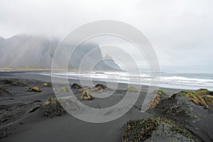 Sand dunes and Vestrahorn mountain during overcast day in Stokksnes peninsula in Iceland.