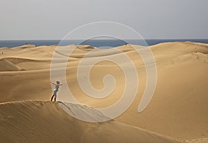 Sand dunes views sea with a woman who fly on it