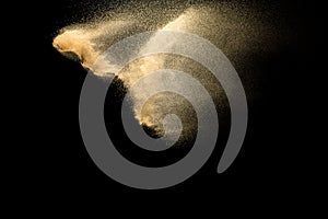 Sand explosion isolated on black background. Freeze motion of sandy dust splash