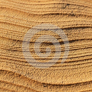 The sand is fine and light brown, with shadows emphasizing the undulating