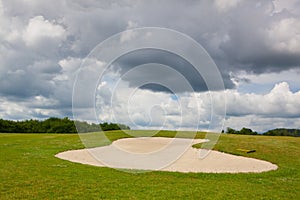 Sand golf bunker on a empty golf course before rain