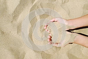 Sand in hands of girl. Hand strew sand photo
