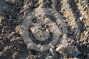 Sand lies in the center of city at a  site. construction vehicles are driving on the sand for the construction complex. footprints