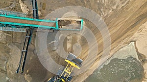 Sand mining industry. Bulldozer machine. Crawler bulldozer moving at sand mine. Mining machinery working at sand quarry. Drone