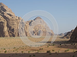 Sand, mountains and sparse vegetation in the Wadi Rum desert, Jordan