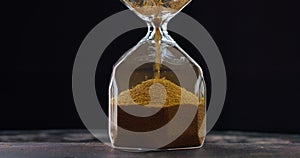 Sand moves through hourglass. Close up of hour glass clock. Old time classic sandglass timer. Sand is falling down and