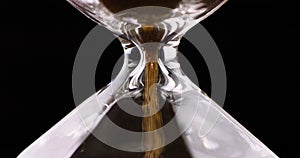 Sand moves through hourglass. Extreme close up of hour glass clock. Old time classic sandglass timer. Closeup sand is