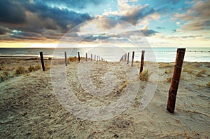 Sand path to North sea beach at sunset