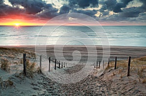 Sand path to North sea beach at sunset