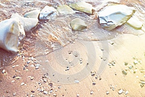 Sand pebbles beach and the waves on sea at sunset or dawn