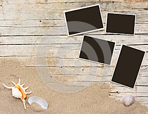 Sand and photographs on planked wood. Summer background with copy space. Top view