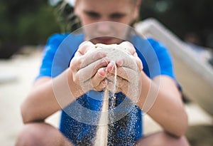 Sand is pouring through fingers.