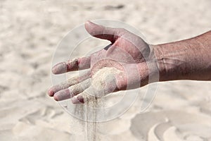 Sand pours from the male palm close-up
