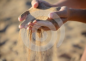 Sand pours out of the hands photo