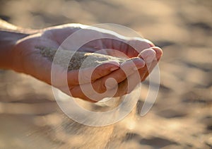 Sand pours out of the hands photo