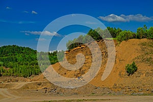Sand quarry with a yellow tractor inside