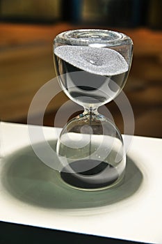 Sand running through the bulbs of an hourglass that measures the passing time in a countdown to a deadline