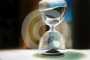 Sand running through the bulbs of an hourglass that measures the passing time in a countdown to a deadline