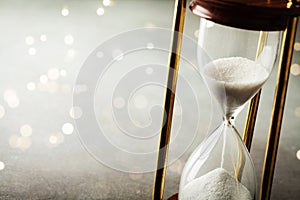 Sand running through the hourglass. Time keeper concept. Boke effect.