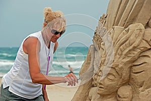 Sand sculptor working on beach