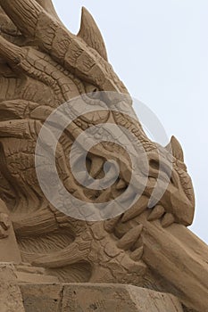 Sand sculpture - chained dragon. Head, right view. Close-up