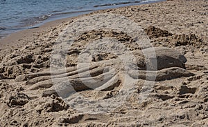 Sand sculpture of an octopus on the sea beach on a sunny day