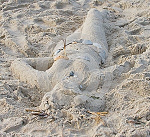 Sand sculpture of a woman with sea shell suit.