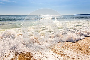 Sand sea beach and blue sky after sunrise and splash of seawater