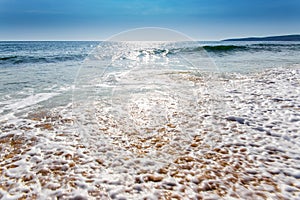 Sand sea beach and blue sky after sunrise and splash of seawater