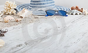 Sand and shells and hat on the wooden floor, summer concept