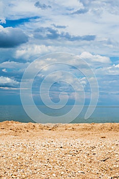 Sand and shelly beach and dark blue clouds