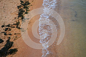 Sand on the shore, sandy shore, wave on the sandy shore, relaxing on the beach.