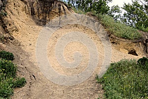 Sand on a slope with green grass