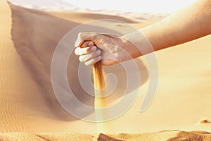 Sand spilling out of the hand. Concept of the transience of time. Selective focus. Shallow depth of field. photo