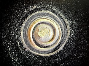 Sand spiral on the black background. The concept of rotation, golden ratio, galaxy