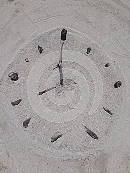 Sand and stick beach clock face 8 o clock