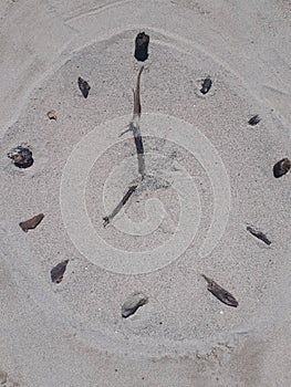 Sand and stick beach clock face 7 o clock