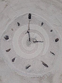 Sand and stick beach clock face 3 o clock