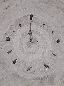 Sand and stick beach clock face 12 o clock