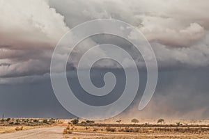 Sand storm in namibia desert, gravel road.
