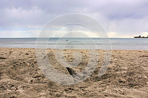 Sand stronghold  on wild sandy beach on rain clouds background.