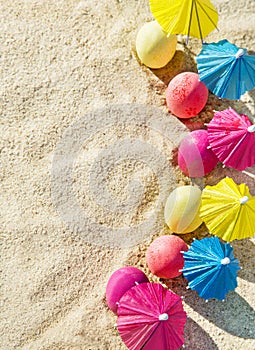 Sand texture (background) with colorful easter eggs with umbrellas on the beach.