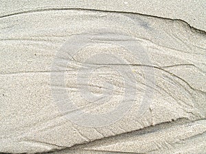 Sand texture background, traces striped of water flow on sand beach